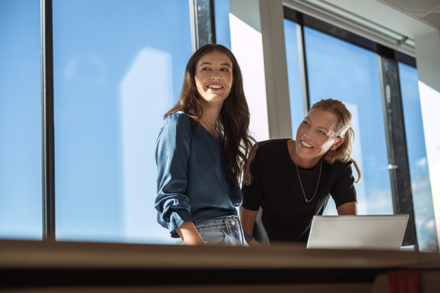 Kristina Jumankina, Data Analyst at Telia, together with a colleague in front of a laptop.