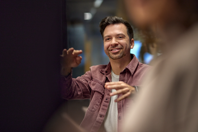 A person is talking to colleagues and demonstrating something with their hands.